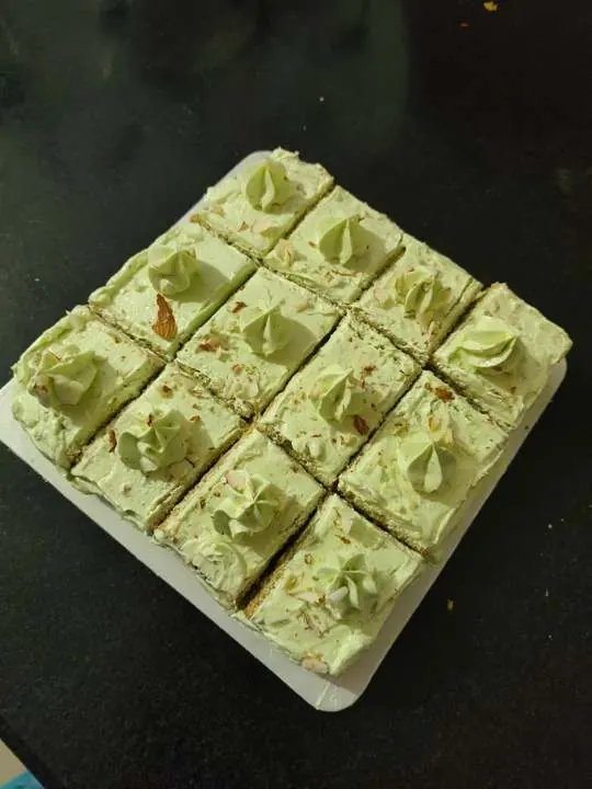 Pistachio pastry slices topped with cream and almond flakes
